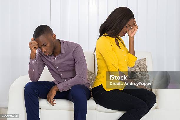 Couple Sitting Back To Back On Sofa Stock Photo - Download Image Now - Divorce, Couple - Relationship, Adult