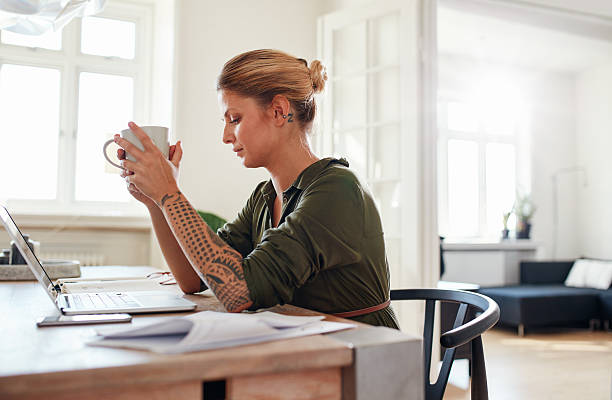 istock Thoughtful young woman with coffee sitting at table 622198216