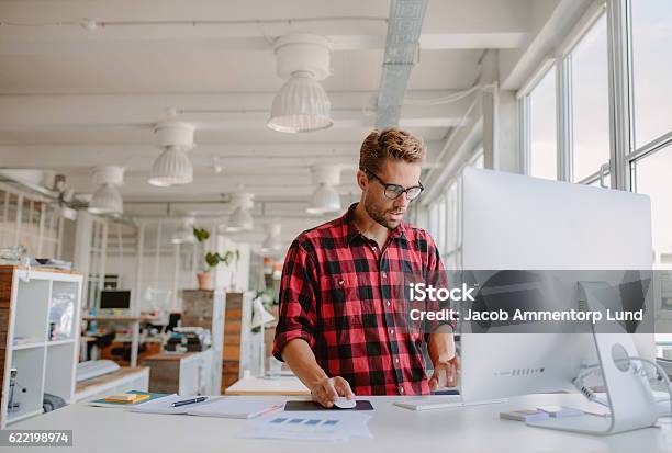 Junger Mann Arbeitet Am Computer Im Modernen Büro Stockfoto und mehr Bilder von Grafiker - Grafiker, Büro, Männer