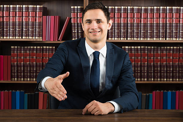 istock Smiling Lawyer Offering Handshake At Desk 622201916