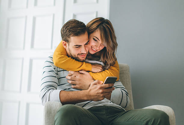 istock Beautiful young couple looking at smartphone 622204244