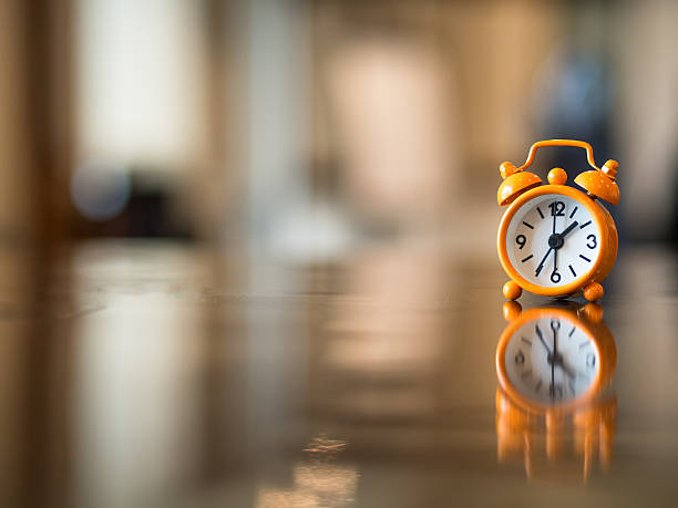istock Old clock orange on the wooden table 622204844