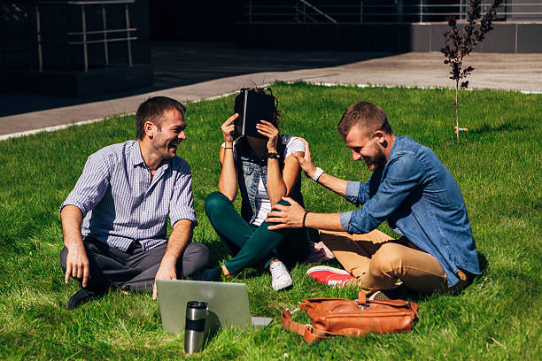 istock three students sit on the lawn and going to lessons 622204860