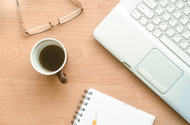 istock Laptop, cup of coffee, glasses and notebook on the desktop 622207312