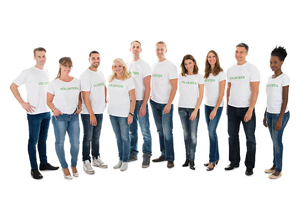 portrait de bénévoles confiants debout dans la rangée - t shirt white men jeans photos et images de collection