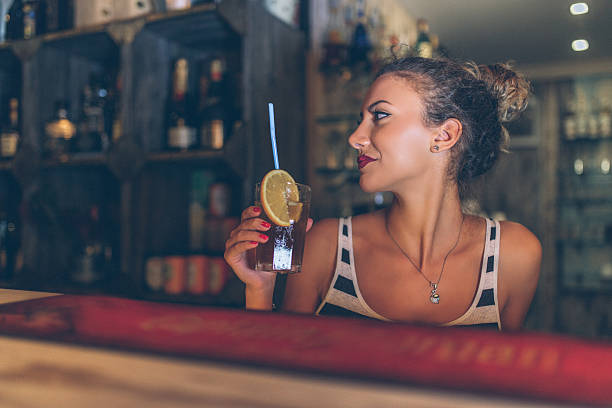 Beautiful young woman drinking healthy juice at cafe
