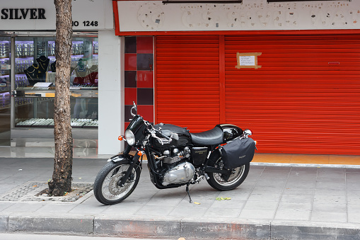 Bangkok, Thailand - June 27, 2015: A vintage motorcycle parks on sidewalk beside Charoen Krung Rd, Driving a vintage motorcycle gaining popular in Thailand