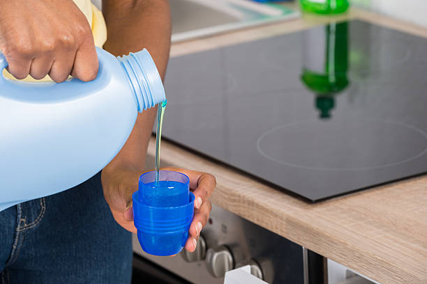 istock Female Hands Pouring Detergent In The Blue Bottle Cap 622210280