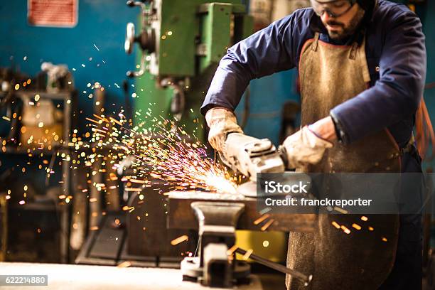 Manual Worker On A Workshop With The Grinder Stock Photo - Download Image Now - Grinding, Construction Site, Grinder - Industrial Equipment