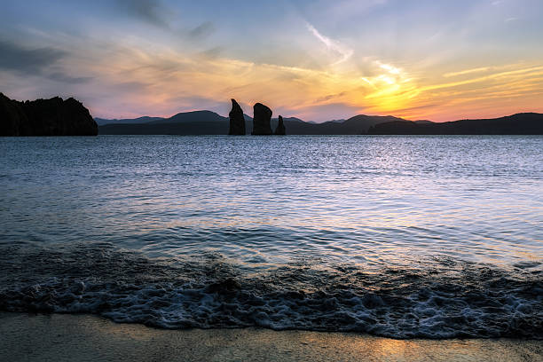 Beautiful view of sunset over rocks in sea stock photo