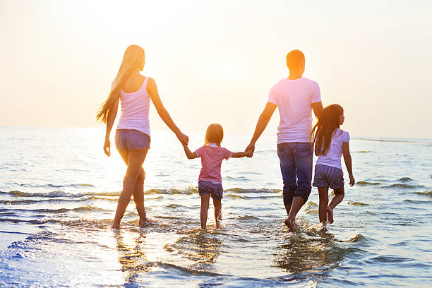 istock Happy young family having fun running on beach at sunset 622218880
