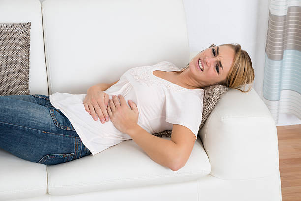 istock Woman Suffering From Stomach Pain While Lying On Sofa 622218952
