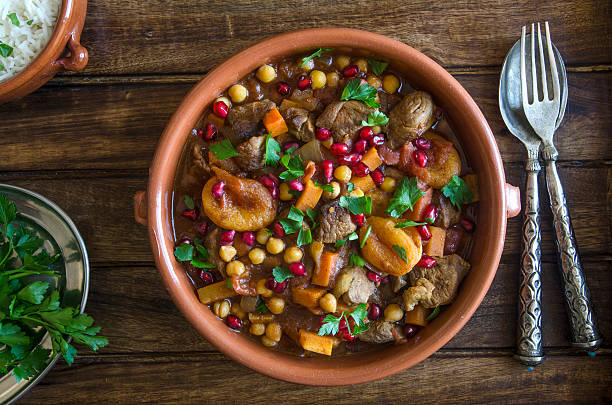 Fruity lamb tagine Lamb tagine with chickpeas, apricots and pomegranate seeds tajine stock pictures, royalty-free photos & images