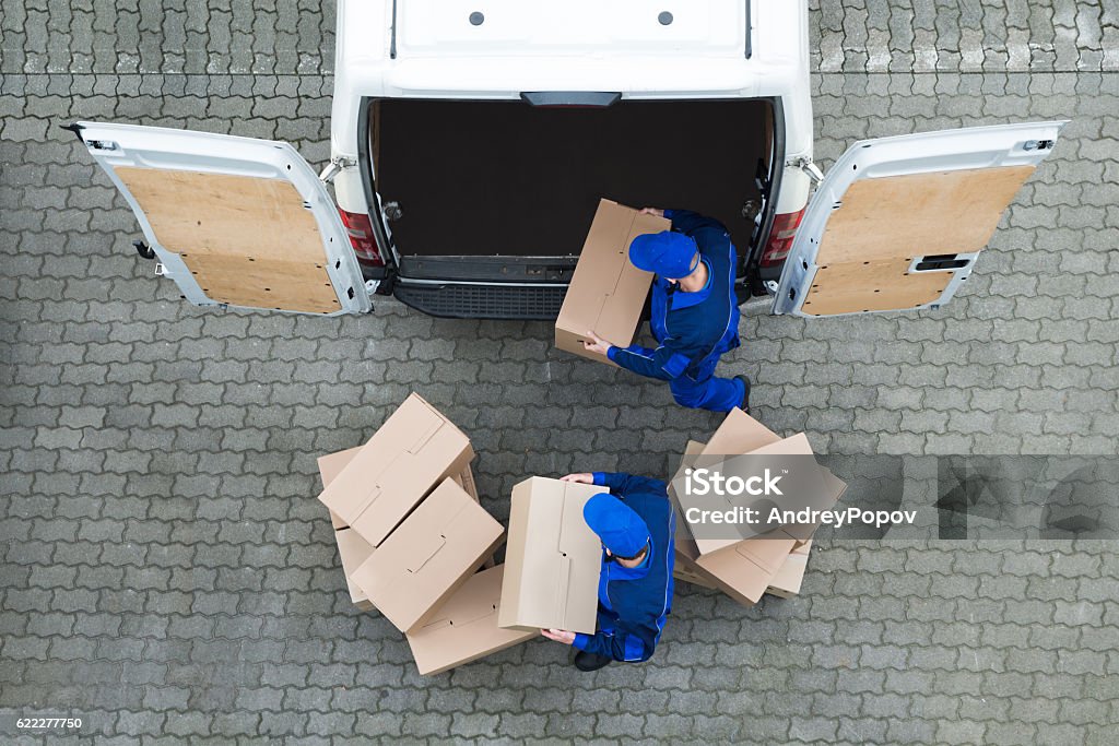 Repartidores descargan cajas de cartón del camión en la calle - Foto de stock de Repartidor libre de derechos