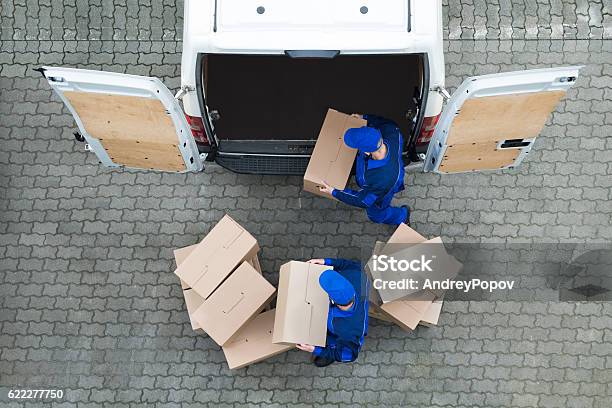 Repartidores Descargan Cajas De Cartón Del Camión En La Calle Foto de stock y más banco de imágenes de Repartidor