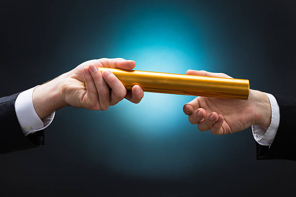 istock Businessman Passing Relay Baton To Colleague 622278074