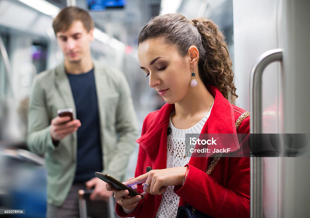 Urban transport scene: couple holding phones Urban transport scene: couple holding cell phones and smiling underground Internet Stock Photo