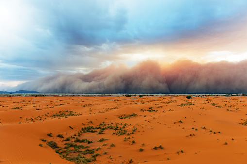 Sandstorm comming fast towards Merzouga in Erg Chebbi Desert, Morocco, Africa. Thin green line is the settlement.Nikon D3x