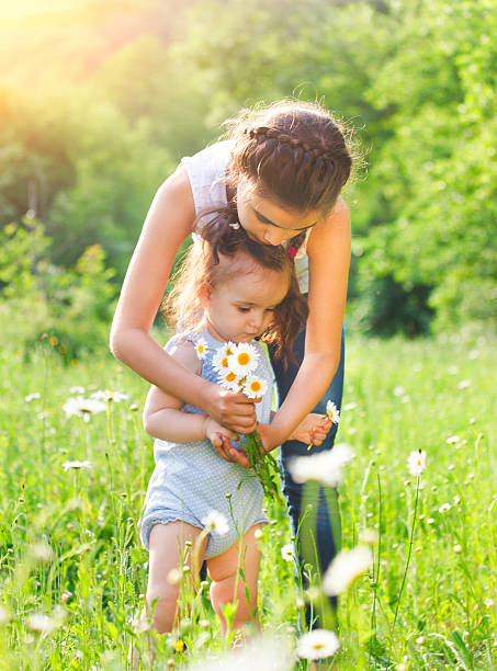 istock Two happy sisters in the daisy spring field 622280218