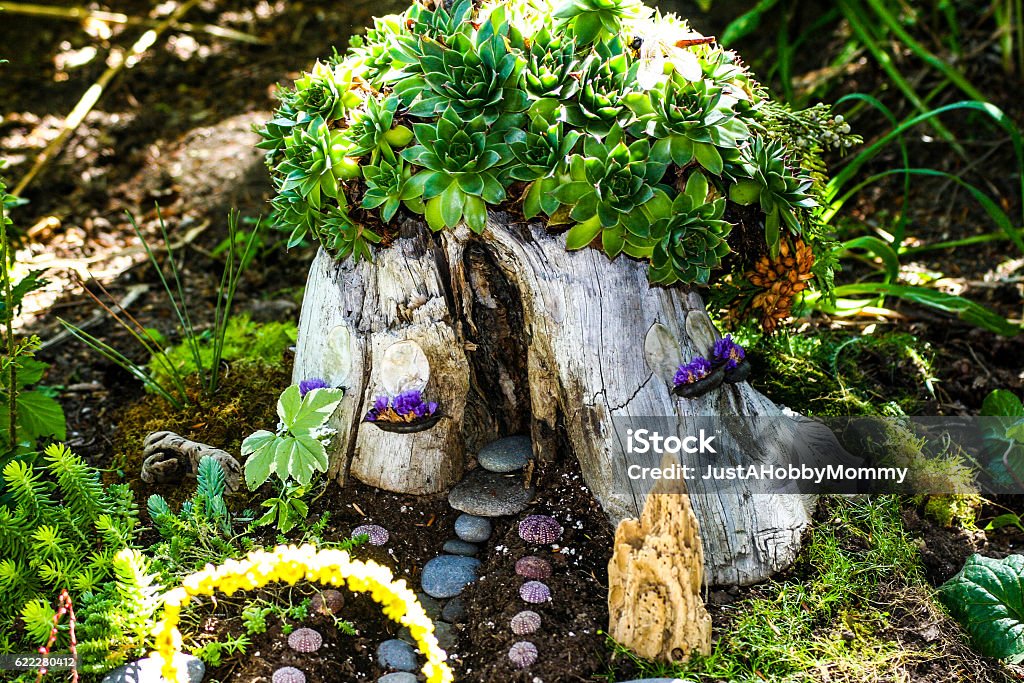 Tree Stump Fairyhouse with Succulents A fairy house or fairyhouse built into a tree stump and covered with green succulents. Fairy Stock Photo