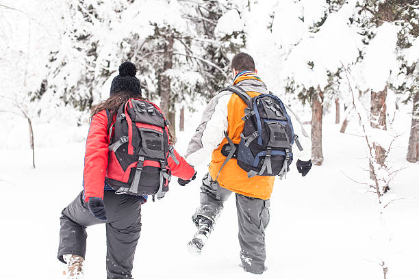 istock Young people with backpacks sinking in snow forest 622283204