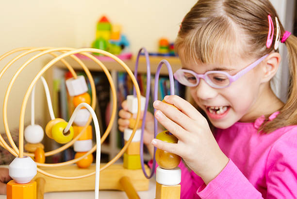 istock Visually disabled child playing with wooden roller coaster bead toy 622284444