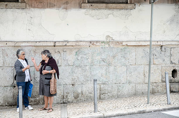 Lisbon, Portugal - October 17, 2016: Two old woman discussing on the sidewalk during a day of autum.
