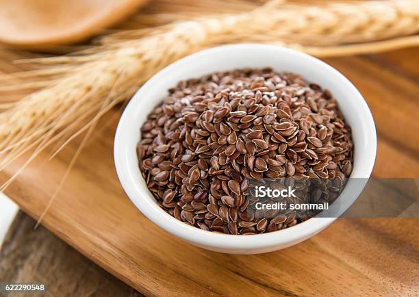 Flaxseeds In White Bowl On Wood Table Stock Photo - Download Image Now - Flax Seed, Agriculture, Backgrounds