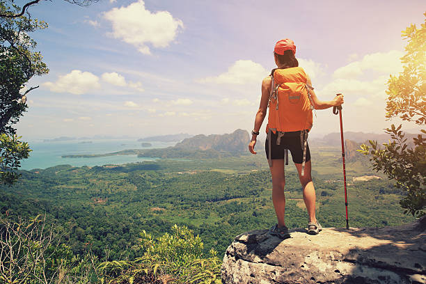 istock successful woman backpacker hiking on mountain peak cliff 622296810
