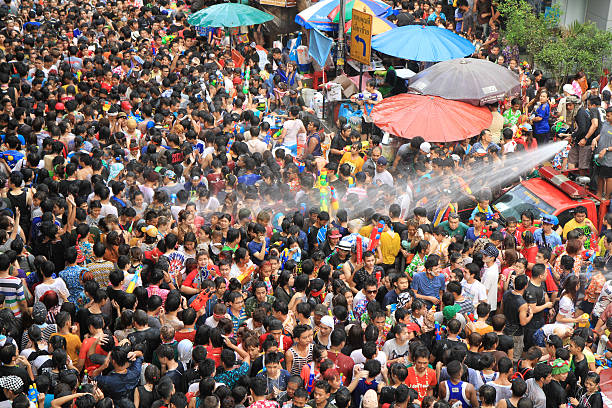 People celebrating the Songkran New Year Festival in Bangkok, Thailand. BANGKOK - APRIL 13: Crowd of people celebrating the traditional Songkran New Year Festival, April 13, 2014, Silom road, Bangkok, Thailand. silom stock pictures, royalty-free photos & images