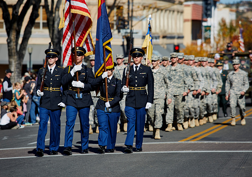 Prescott, Arizona, United States - November 11, 2016: ROTC members marching together holding flags in Veterans day Parade