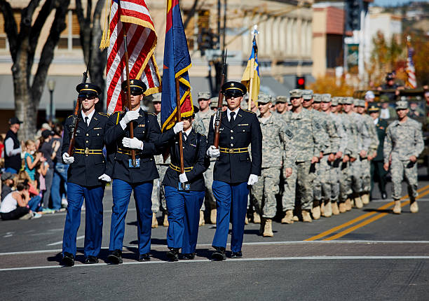 члены rotc маршируют на параде в честь дня ветеранов - us marine corps фотографии стоковые фото и изображения