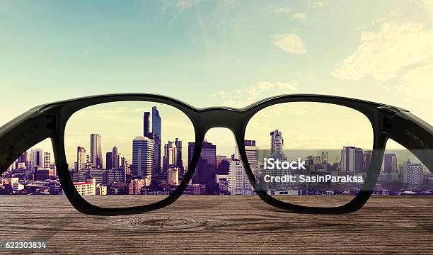 Sunglasses On Wooden Desk With City View Background Stock Photo - Download Image Now