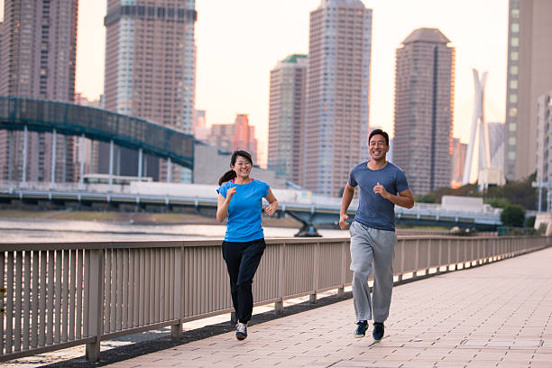 istock Young athletes jogging along river in cityscape 622306036