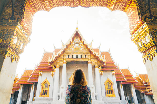 femme regardant le temple wat pho au lever du soleil - wat pho photos et images de collection