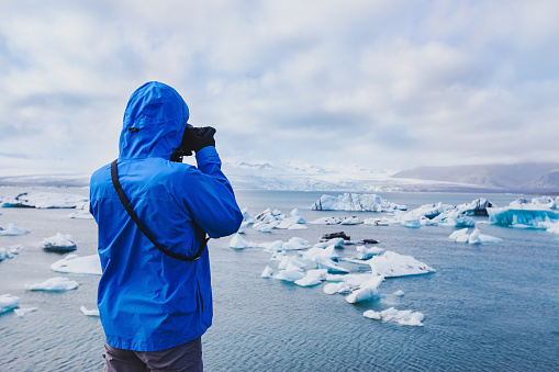 nature travel photographer, person taking photo of arctic icebergs in Iceland