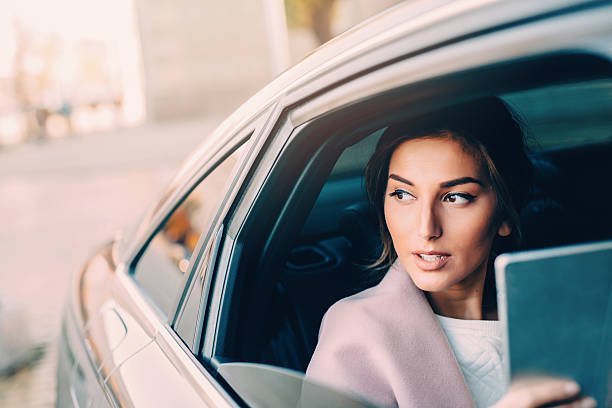 istock Woman using a tablet in a car 622314744