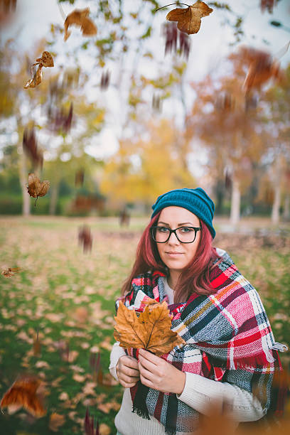 istock autumn leaves falling on happy young woman in forest 622317802