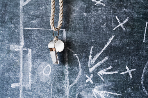 whistle of a soccer / football referee or coach on black board with tactical diagram