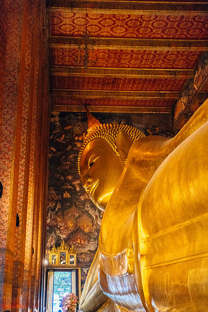 Sleeping golden Buddha statue ancient art of Thailand from Bangkok with warn sun lighting grey tone color.
