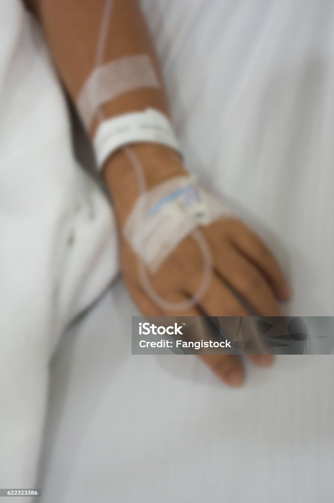 The patient is lying on a bed in the hospital Blurred photo of The patient is lying on a bed in the hospital receiving intravenous chemotherapy. Adult Stock Photo