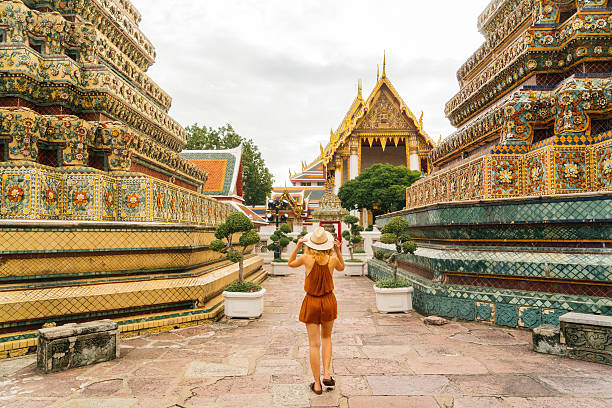 mulher andando no templo wat pho - bangkok thailand asia thai culture - fotografias e filmes do acervo