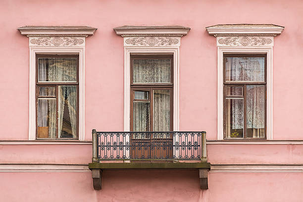 Windows and balcony on facade of apartment building Three windows in a row and balcony on facade of the urban apartment building front view, St. Petersburg, Russia saint petersburg balcony stock pictures, royalty-free photos & images