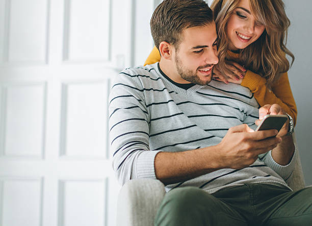 istock Beautiful young couple looking at smartphone 622324916