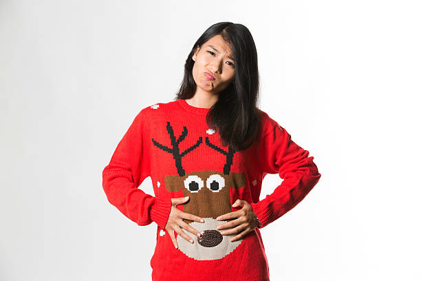 женщина в рождественском свитере она съела слишком много пищи - high cool стоковые фото и изображения