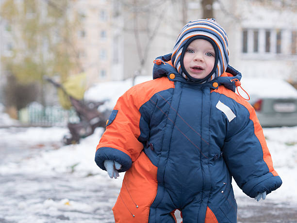 istock Attractive baby boy playing with the first snow. He smiles 622418810