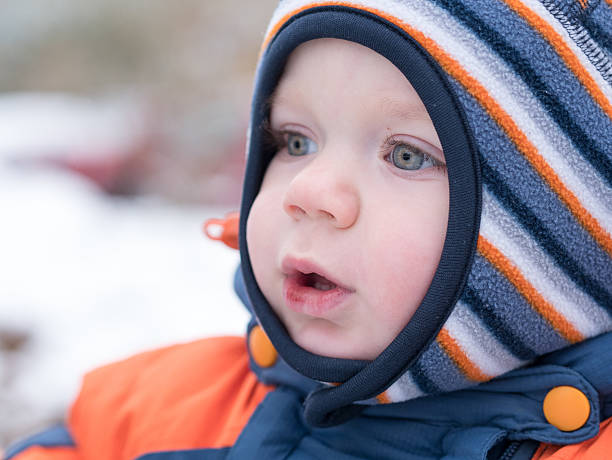 istock Attractive baby boy playing with the first snow. He smiles 622420464