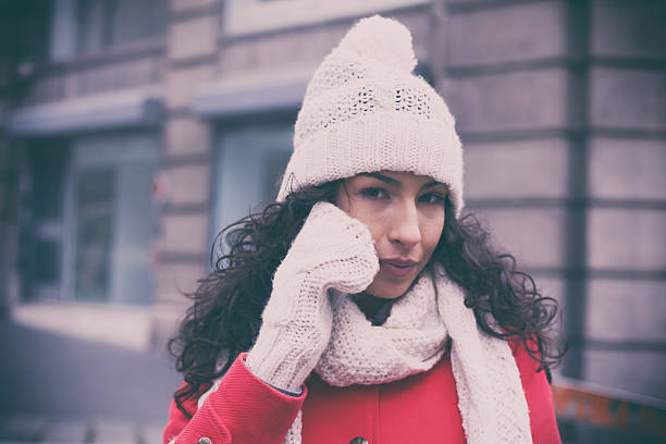 istock Woman in red coat and wool cap with smartphone 622426020