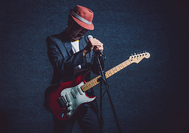 istock Musician playing the guitar with hand holding the microphone 622426592
