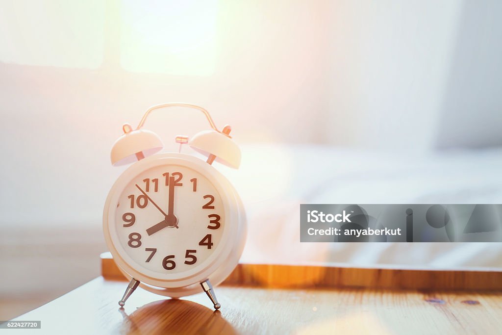 morning time background, alarm clock morning time background, alarm clock near the bed at home Alarm Clock Stock Photo
